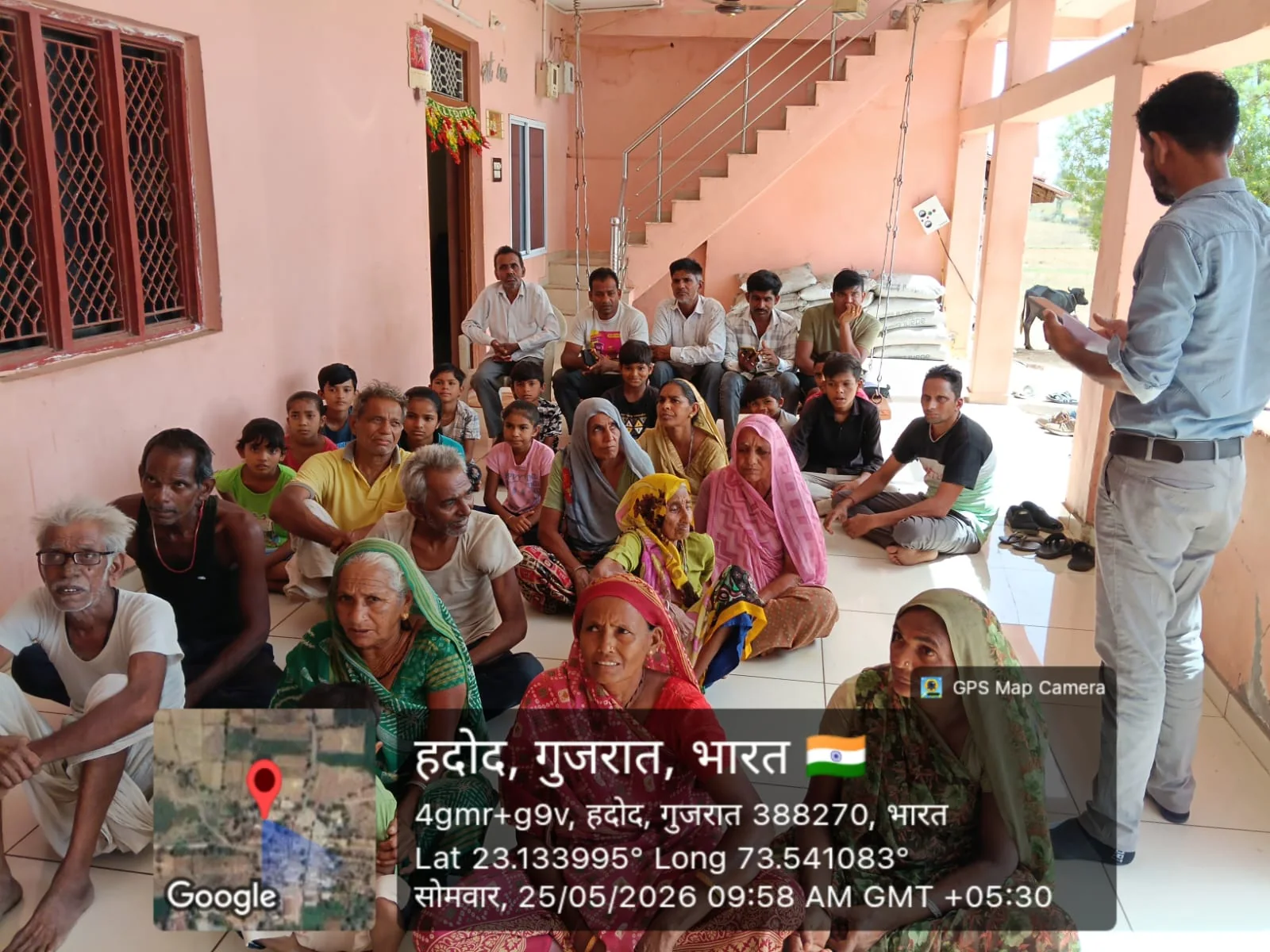 Men, women and children attending a rural community awareness and training meeting