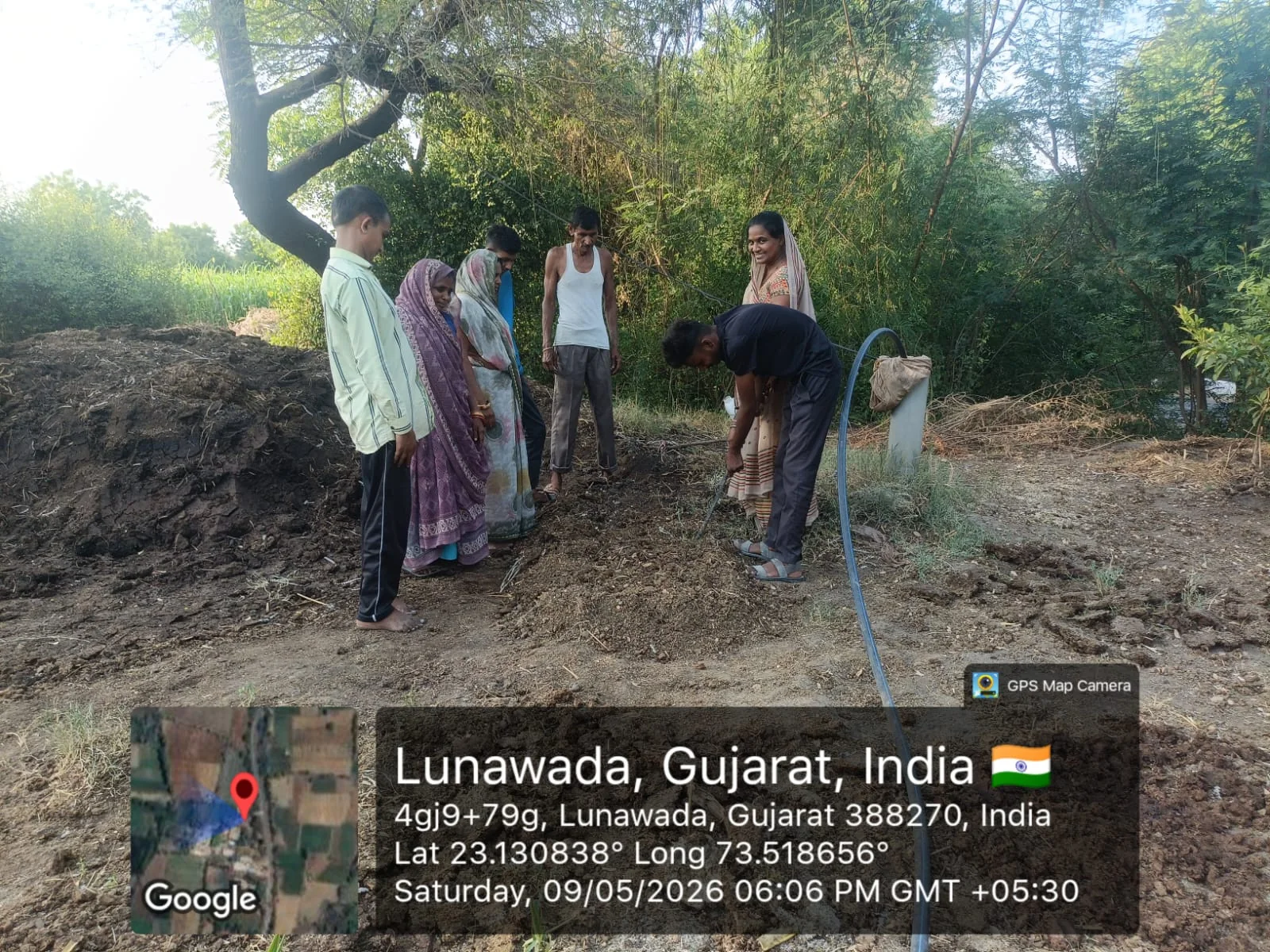 Community members observing an irrigation demonstration in a field near Lunawada
