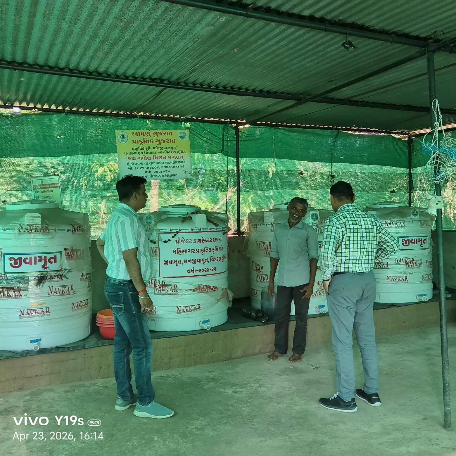 Visitors inspecting large agricultural bio-input tanks at a production unit
